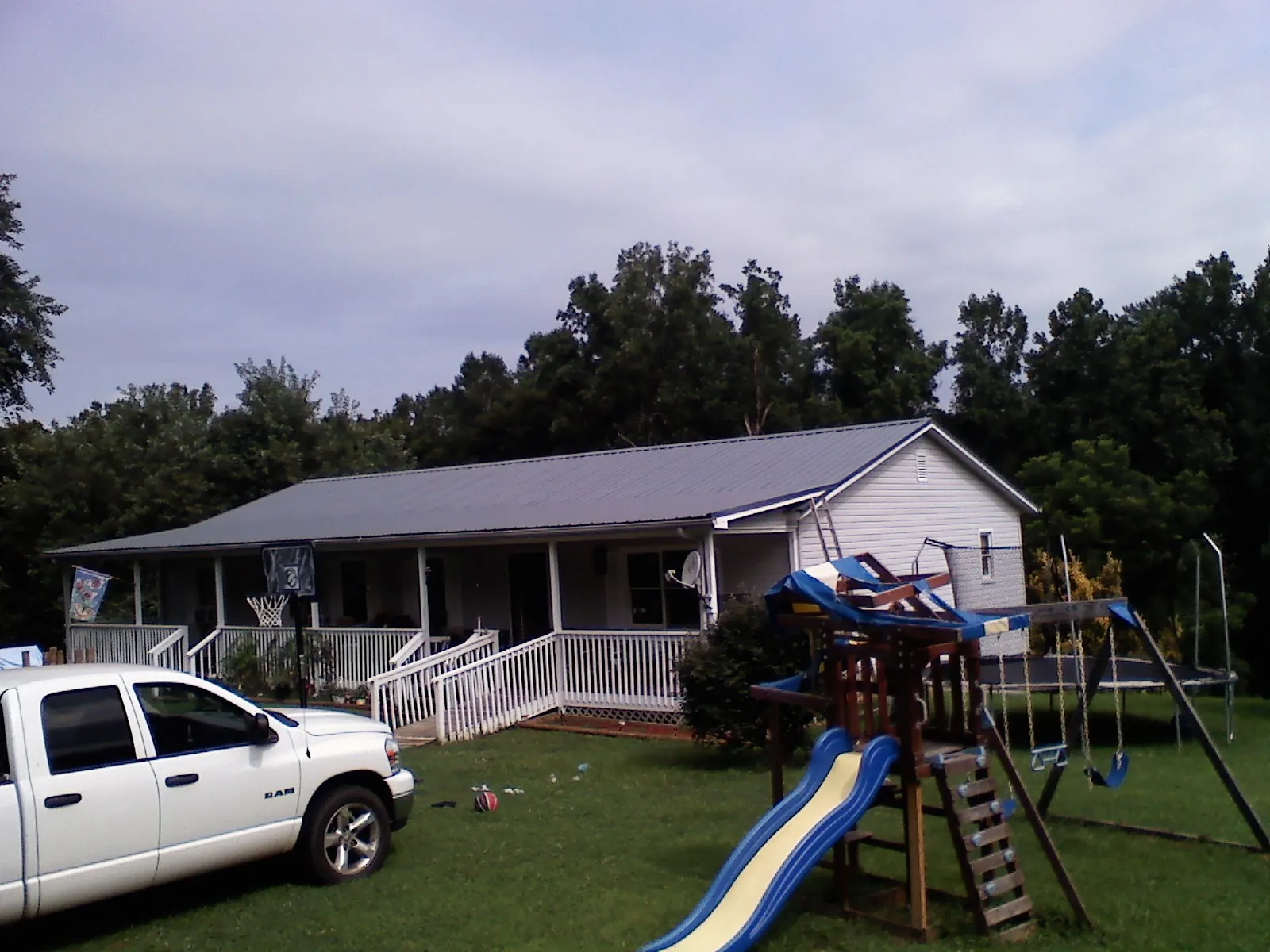 Dark metal roof on a country home with a full length front porch in Cleveland